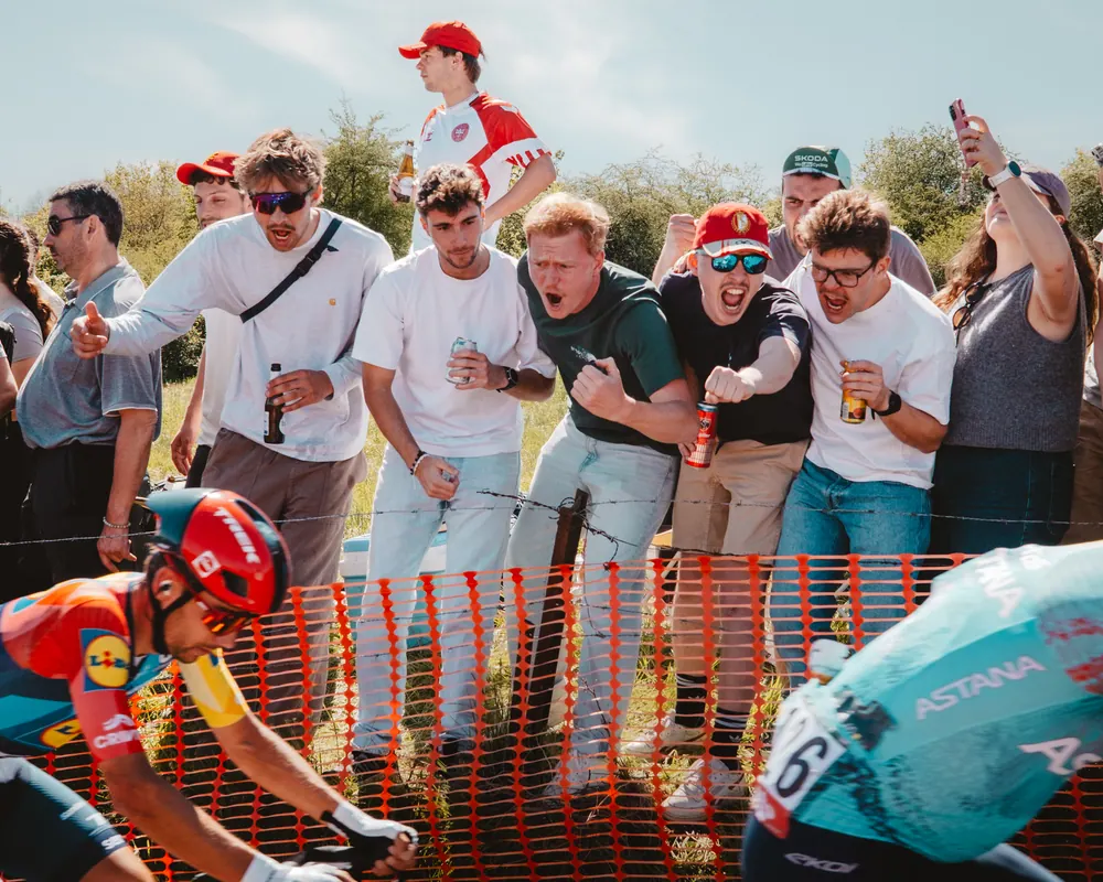 Fans schreeuwen langs de kant terwijl het peloton passeert