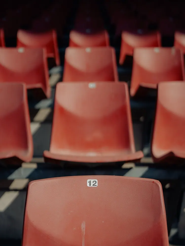 Rood stoeltje met nummer 12 in de lege tribune